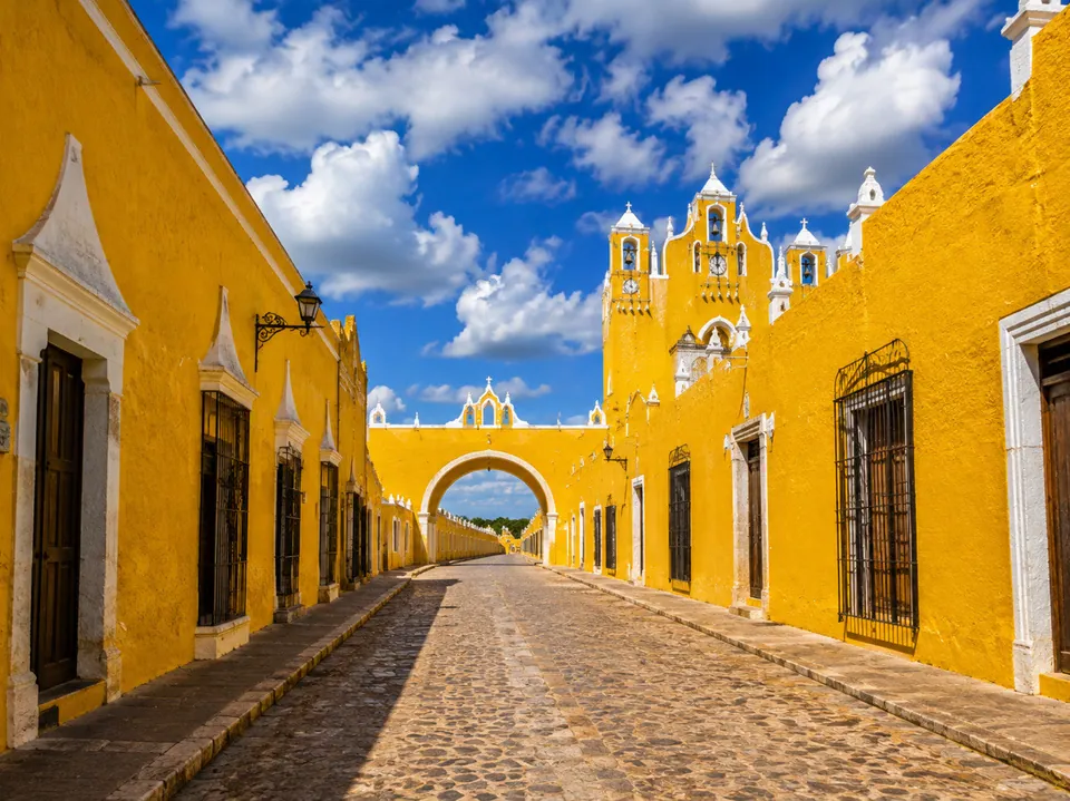 Une rue jaune et l’arche du couvent de San Antonio de Padua à Izamal