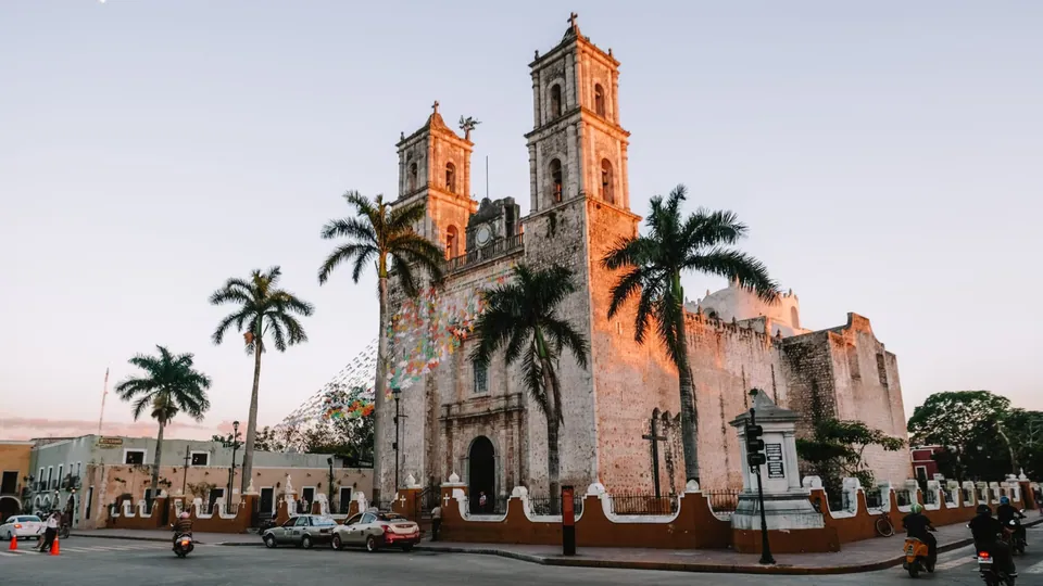 Une église bordée de palmiers au coucher du soleil à Valladolid